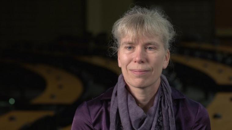 Prof. Katrina Merkies head shot sitting in dark lecture hall