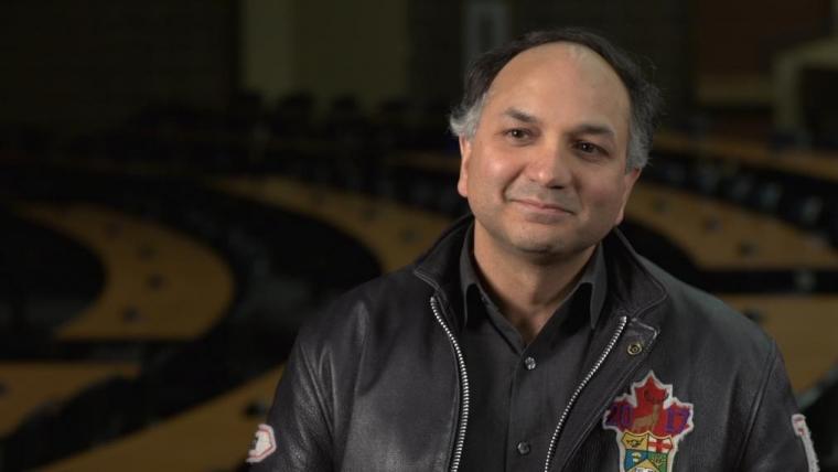 Head shot of Prof. Manish Raizada wearing a leather "Aggie" jacket