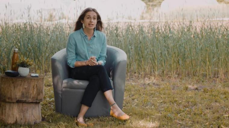 Margarita sits on soft arm chair in front of a green field