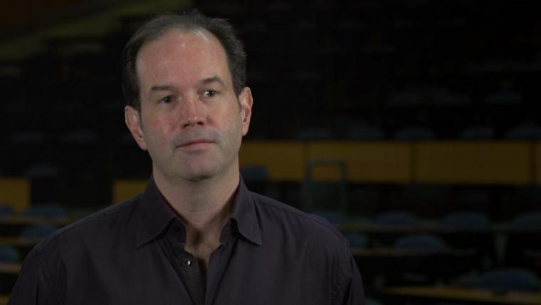 Head shot of Neil Rooney in dark lecture room