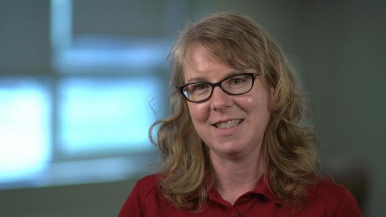 Head shot of Laura Van Eerd wearing red shirt in front of windows