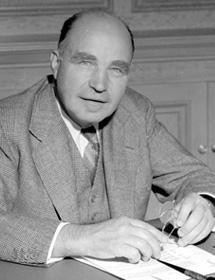 Black and white photo of Harvey Reginald MacMillan sitting at desk.