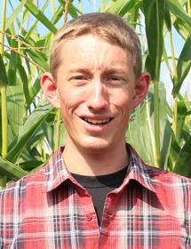 Jacob Nederend headshot in front of a field of corn.