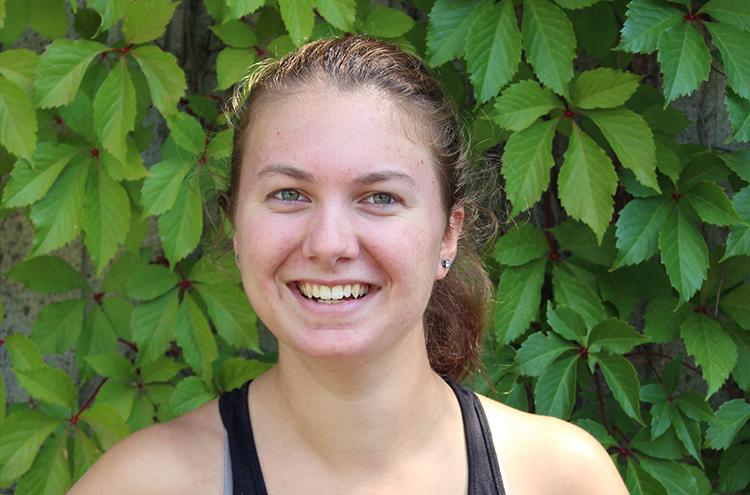 Jordan, wearing black tanktop, in front of green leaves