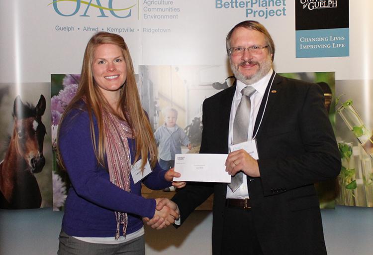 Laura Nanne is presented a cheque by a prof in a suit