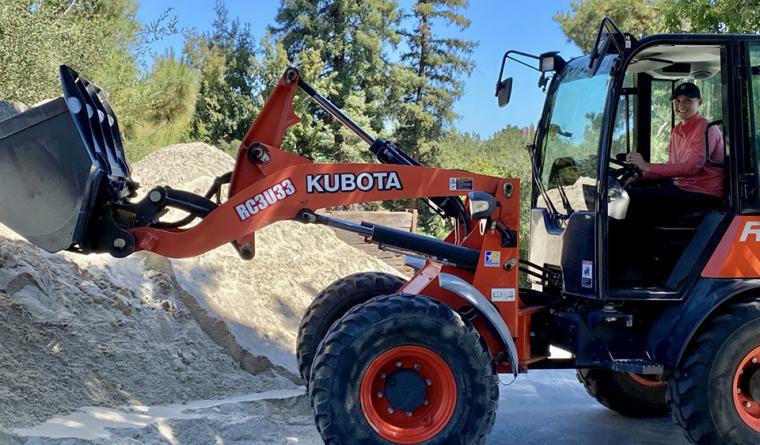 Lauren Lasocha sitting in a Kubota tractor, moving sand for a fairway top dress.