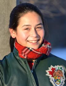 Headshot of Margaret Chan wearing red scarf and green leather jacket.