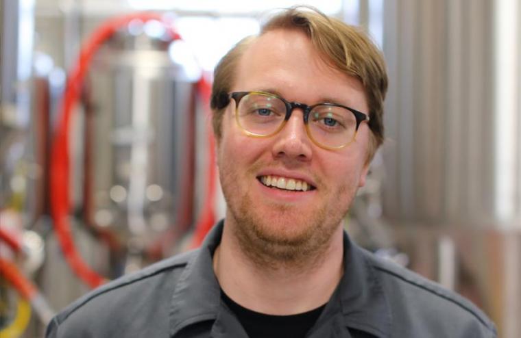 Patrick with brewing equipment behind him