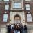 A large group of students stands in front of a beautiful brick building.