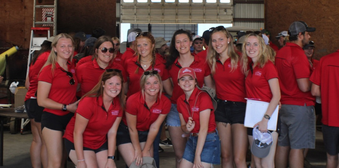 A group of women students in red shirt.