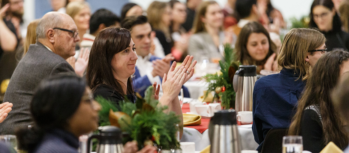 A focus on a woman clapping during an awards celebration.