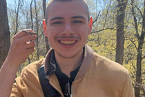 Head shot of Brad smiling in a forest.