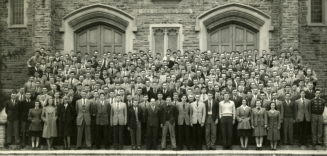 A black and white photo of the class of 1951, in front of War Memorial Hall.
