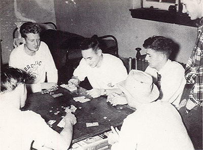 A black and white photo of students playing cards in 1950.