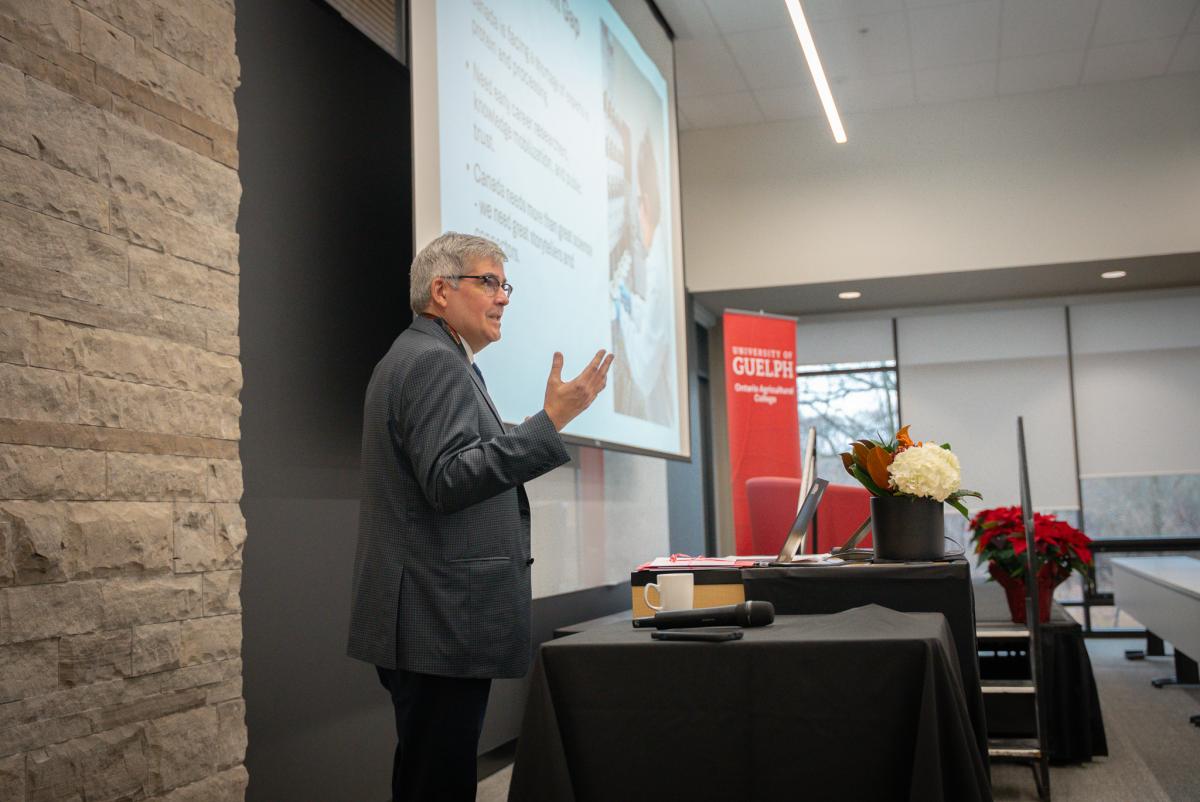 OAC dean john cranfield speaking. he's wearing a suit and tie