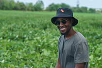 Head shot of Deus Mugabe standing in a field of soybeans.
