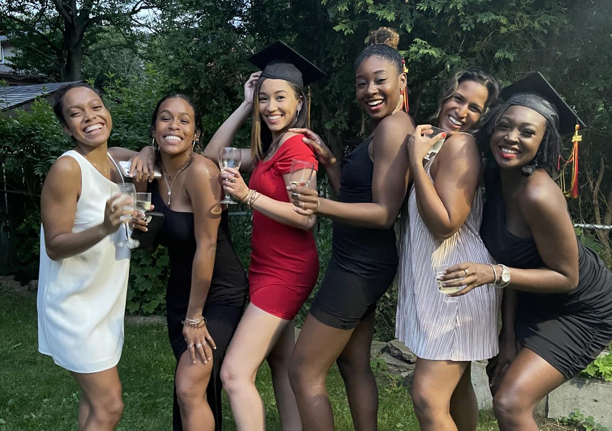 A group of students in formal attire, celebrating their graduation.