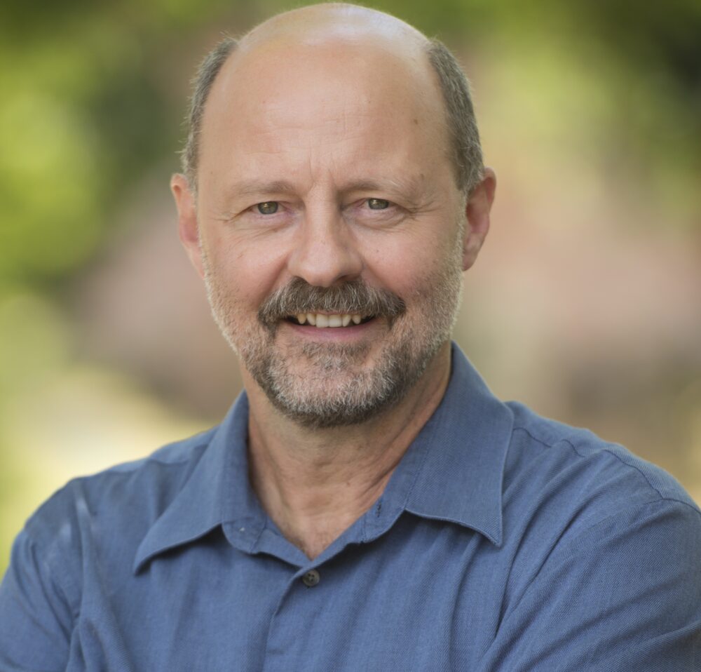 dr flavio schenkel standing outside in a green space