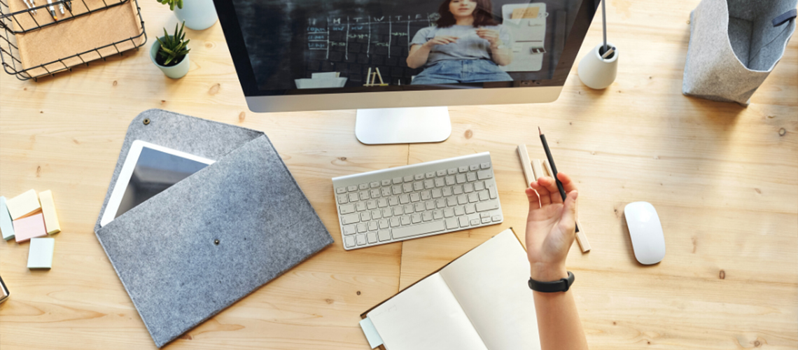 A person works at a desk while watching a video.