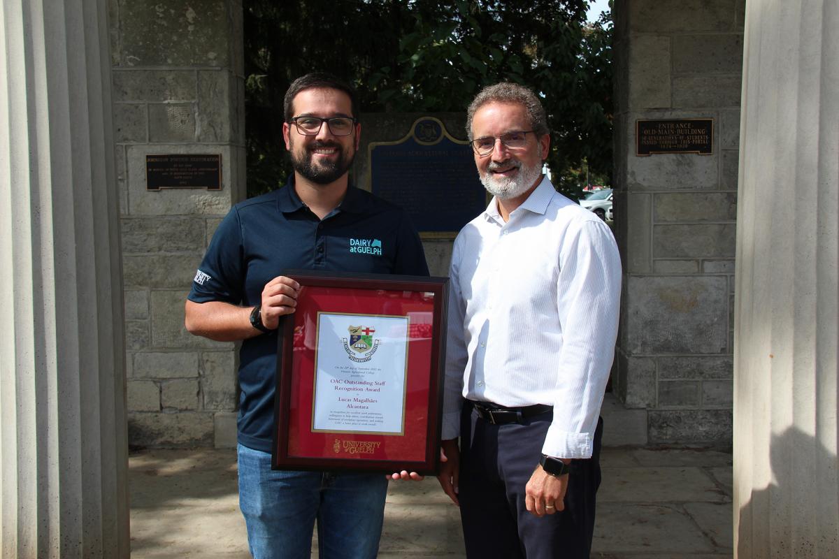 Lucas standing beside the OAC Dean, while holding a frame.