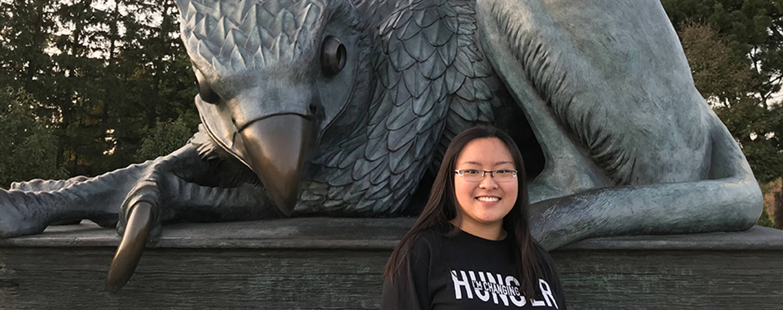Mandy Lam standing in front of the Gryphon statue.