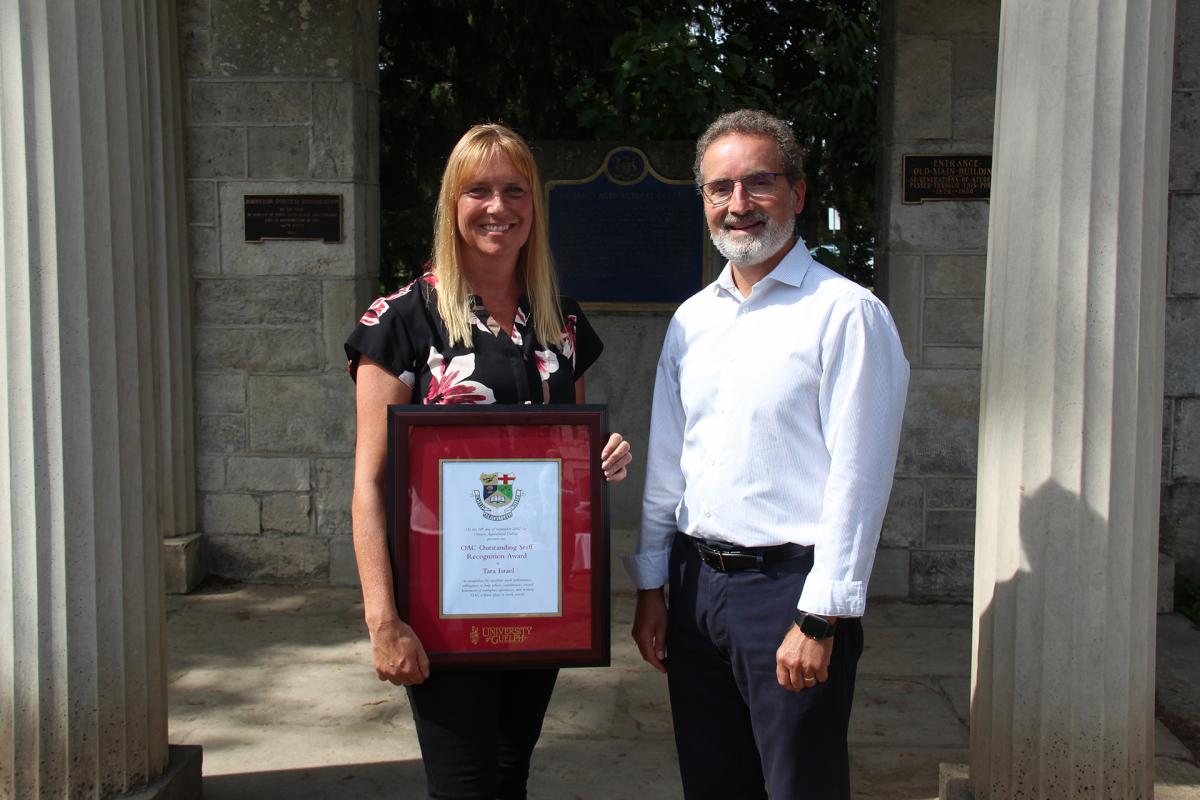 Tara holding a frame standing next to the OAC Dean.