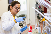 Student in lab coat work in a food science lab.