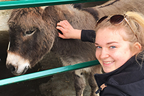 Natalia poses with a donkey.