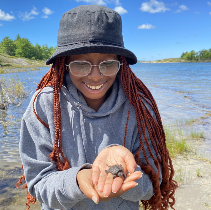 sandreka outside holding a baby turtle