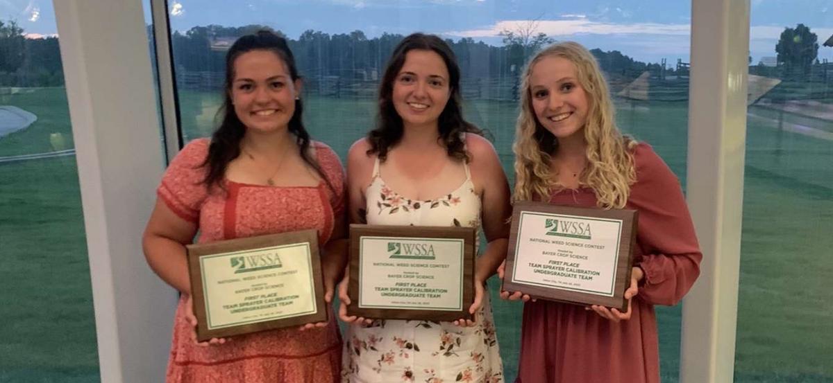 students holding framed awards