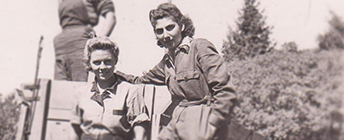 Rosalind and Erika stand together on a cart in work coveralls in 1942.