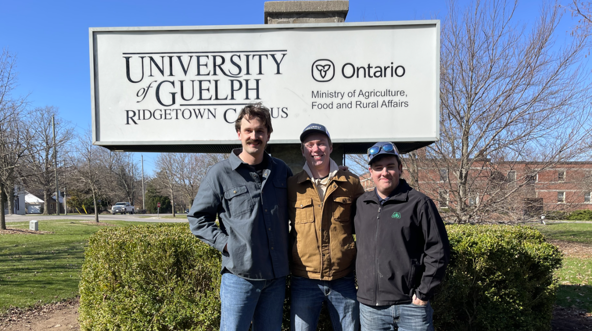 wyatt and others standing infront of the Ridgtown Campus sign