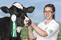 Emma poses with a cow.