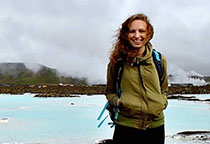Jamie stands with a bright blue lake and mountains behind her.