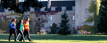 Three students walk across Johnston Green.