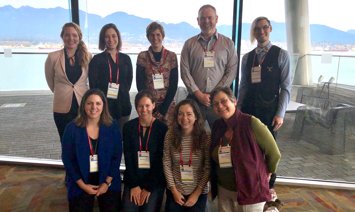 Group of graduate students stand together with Prof. Nigel Raine