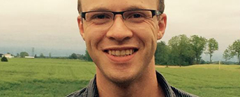 Close up of Joshua with a farmer's field behind him.