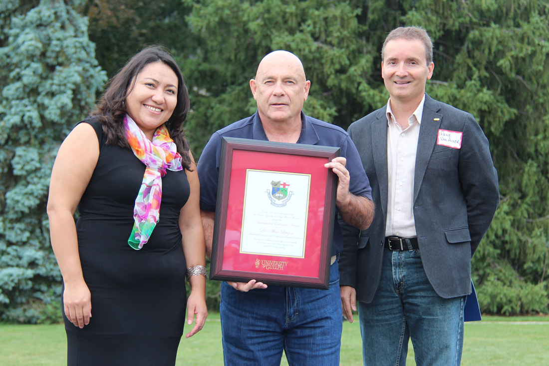 Rocio Morales Rayas, Al Lauzon and Rene Van Acker pose outside with framed certificate