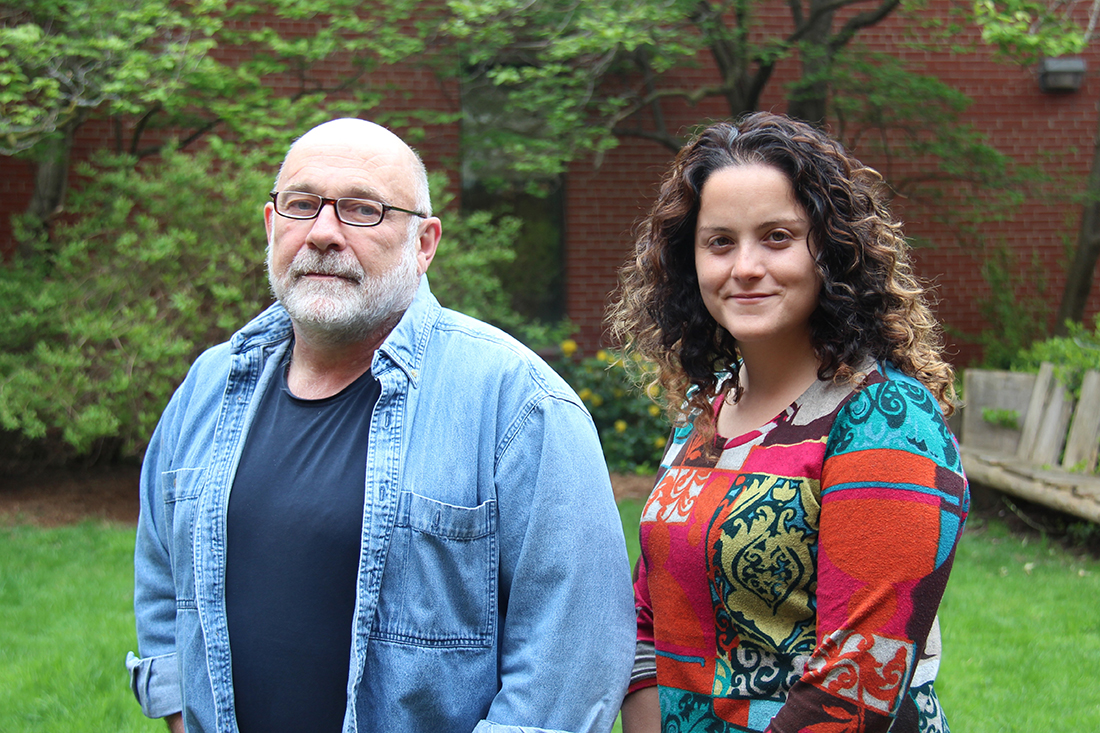 Al Lauzon and Valencia Gaspard stand in front of green trees and brick wall