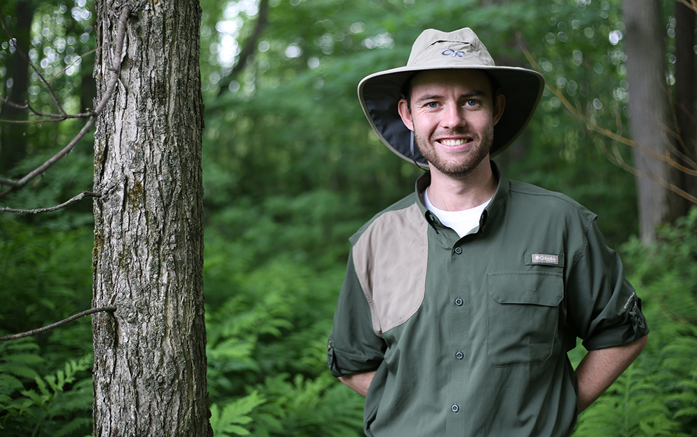 Head shot of Cameron in the woods. 