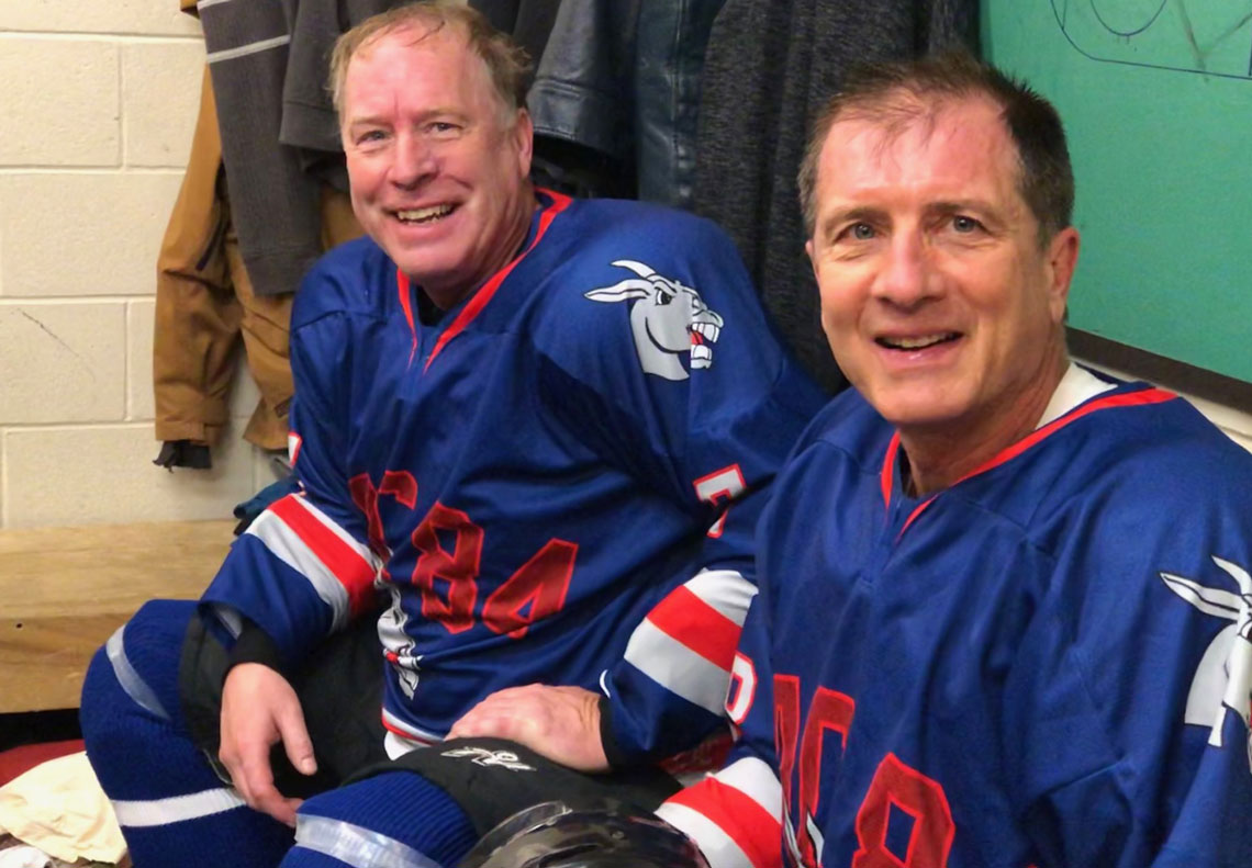 Dave and Ken smiling wearing blue hockey jerseys