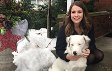 Emma hugging white dog.