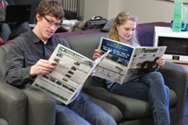 Two students read the Ontario Farmer newspaper.
