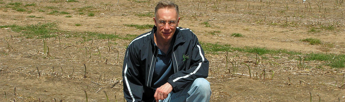 Dave Wolyn poses in an asparagus field