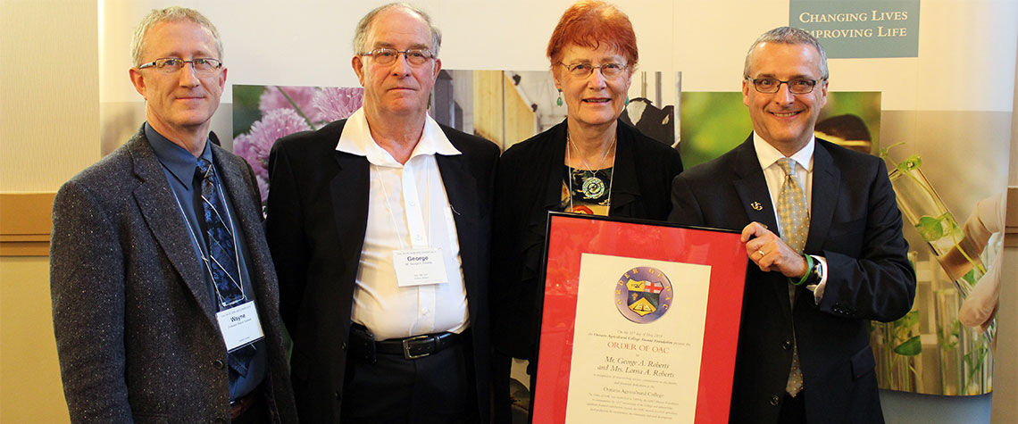 Wayne Caldwell, George Roberts, Lorna Roberts and Rob Gordon pose infront of OAC banner with framed Order of OAC print