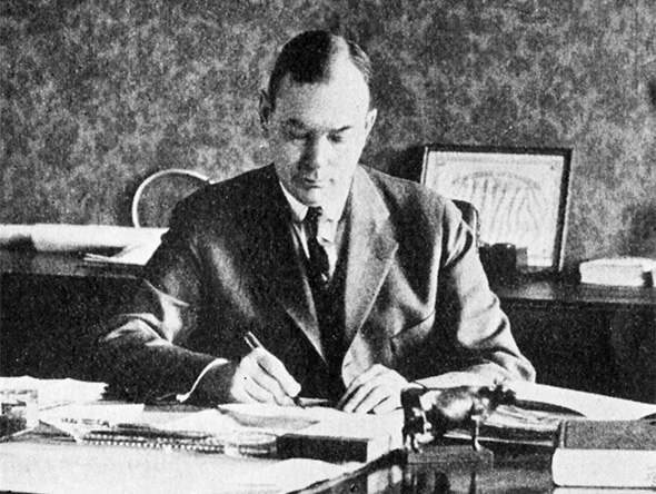 Black and white photo of Christie at his desk