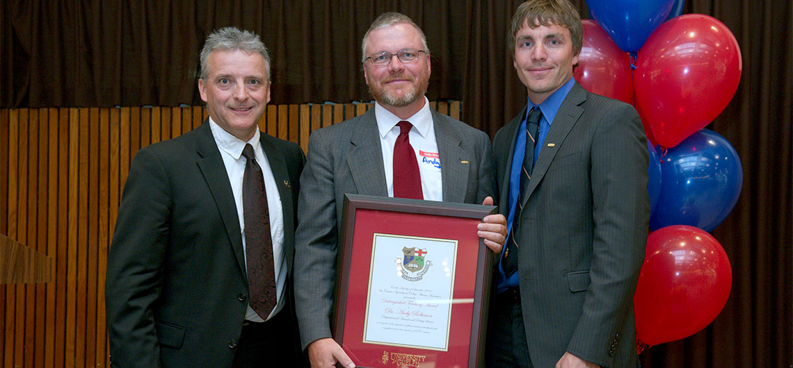 Rob Gordon and Clint Buttar present Prof. Andy Robinson with framed award