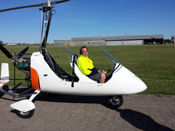 Nate sitting in a small gyroplane on the runway