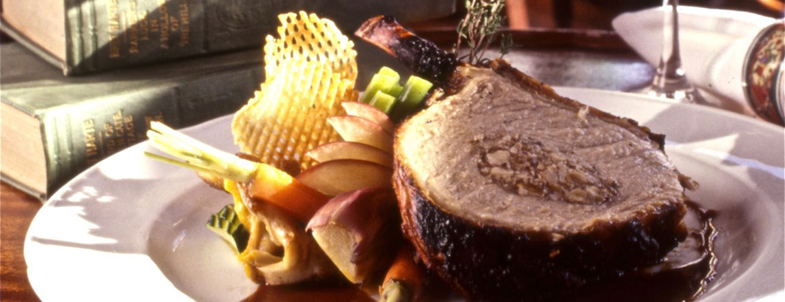 Picture of stuffed pork on a plate with a glass of wine.