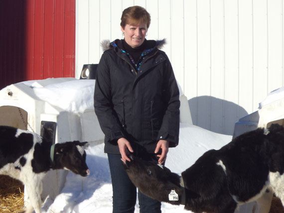 Karen Eastman Velthius with a calf on her farm